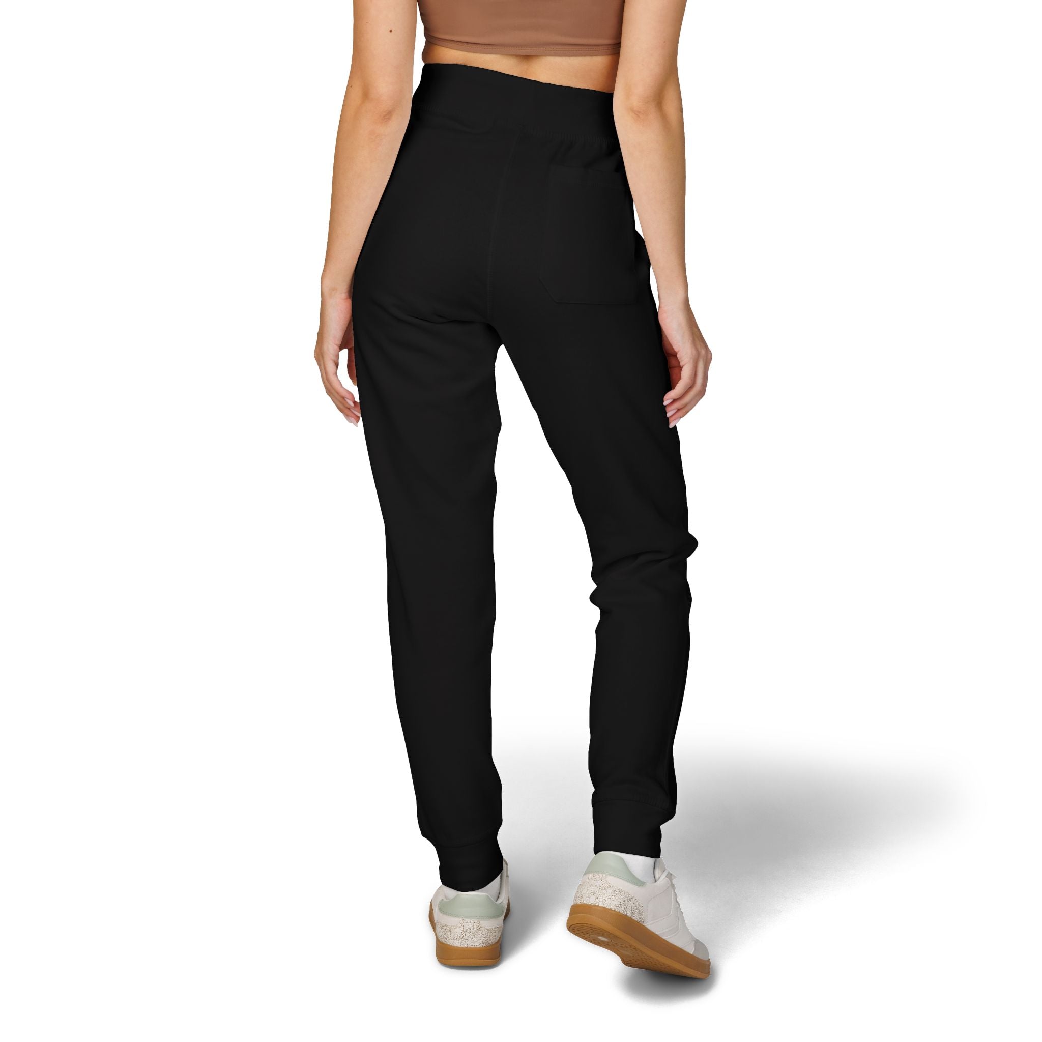 Person wearing black jogger pants on a white background