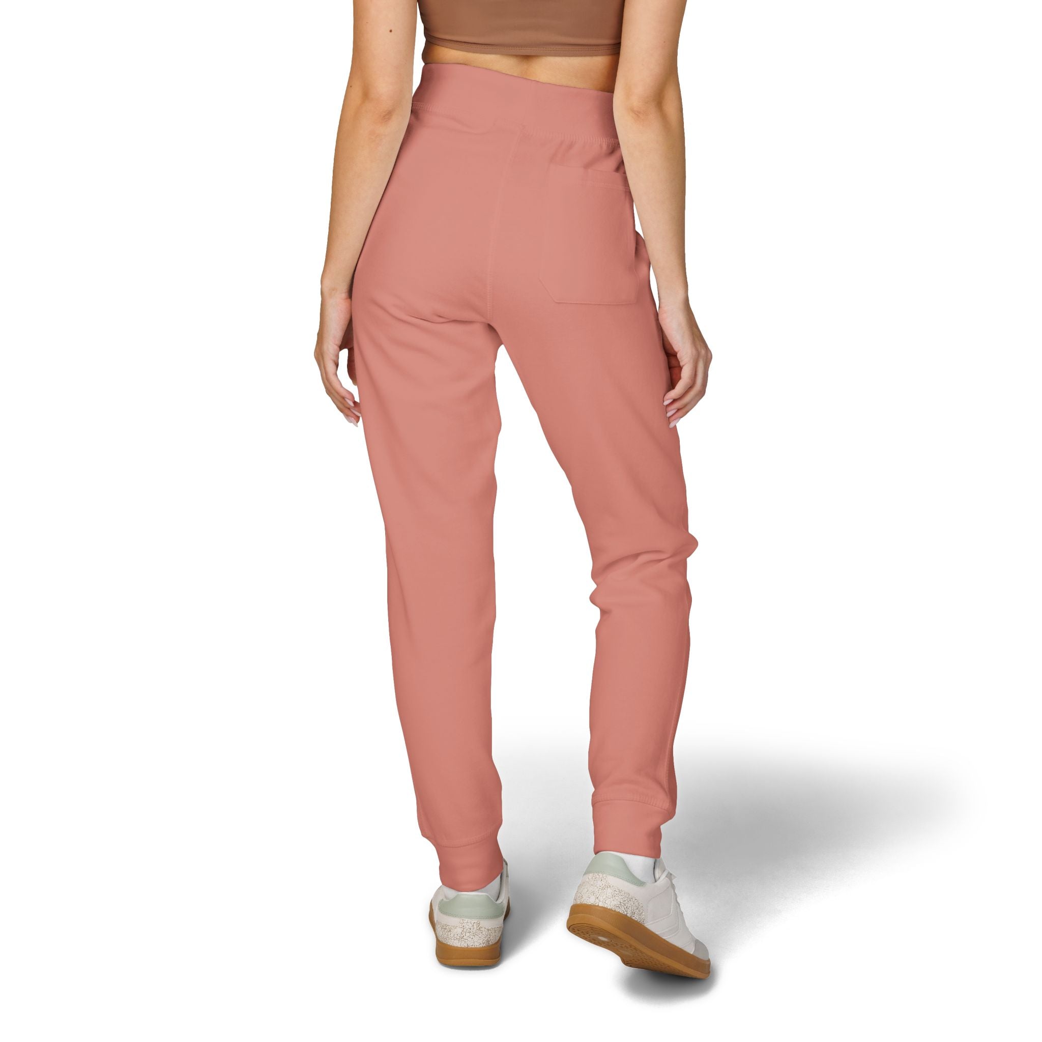 Person wearing pink jogger pants on a white background